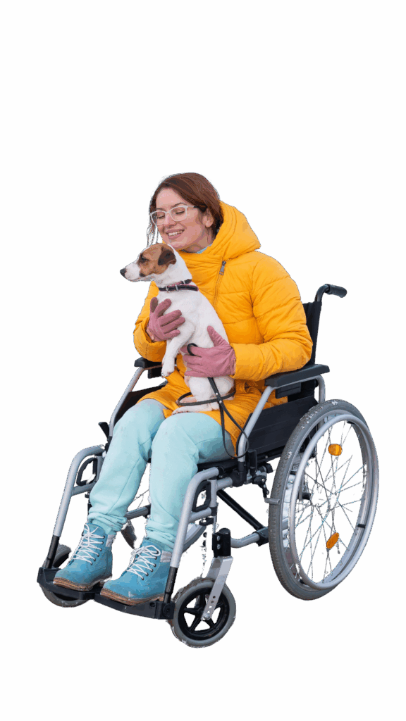 Frau mit kleinem Assistenzhund und einer Gehbehinderung. Sie sitzt im Rollstuhl. Der Assistenzhund auf ihrem Schoß